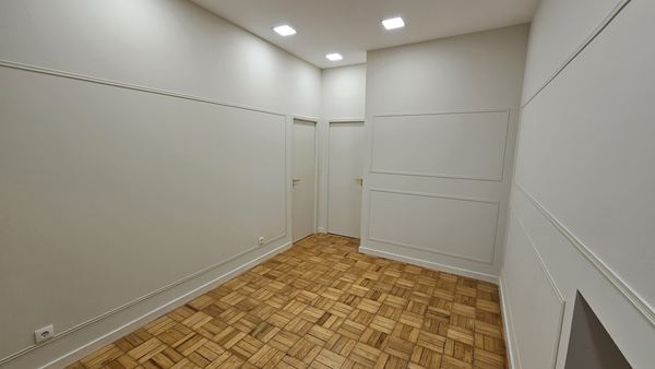 Parede com boiserie branca em painéis e molduras