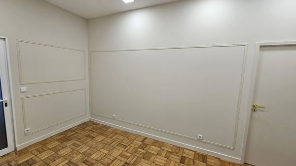 Boiserie branca com painéis junto à porta