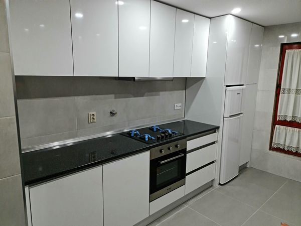 Cozinha branca brilhante com bancada preta