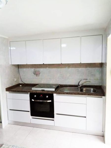 Cozinha branca brilhante com bancada de granito