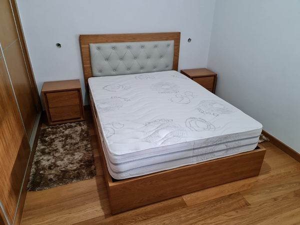 Cama com cabeceira estofada e mesas de cabeceira