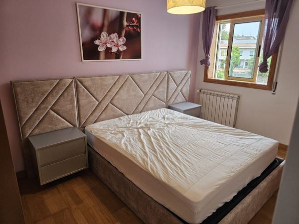 Cama estofada com cabeceira larga em painéis