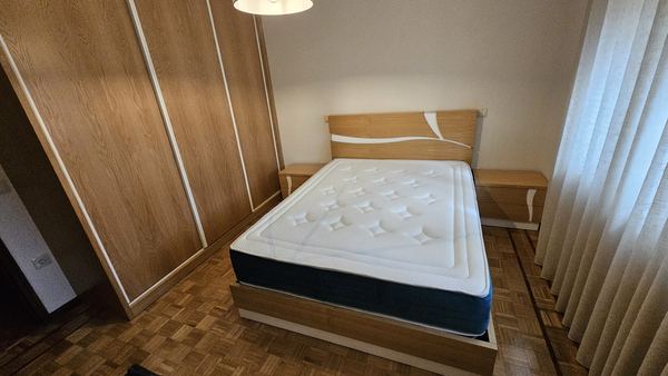 Quarto com roupeiro de correr e cama em madeira