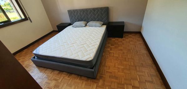 Cama estofada cinzenta com cabeceira em espinha